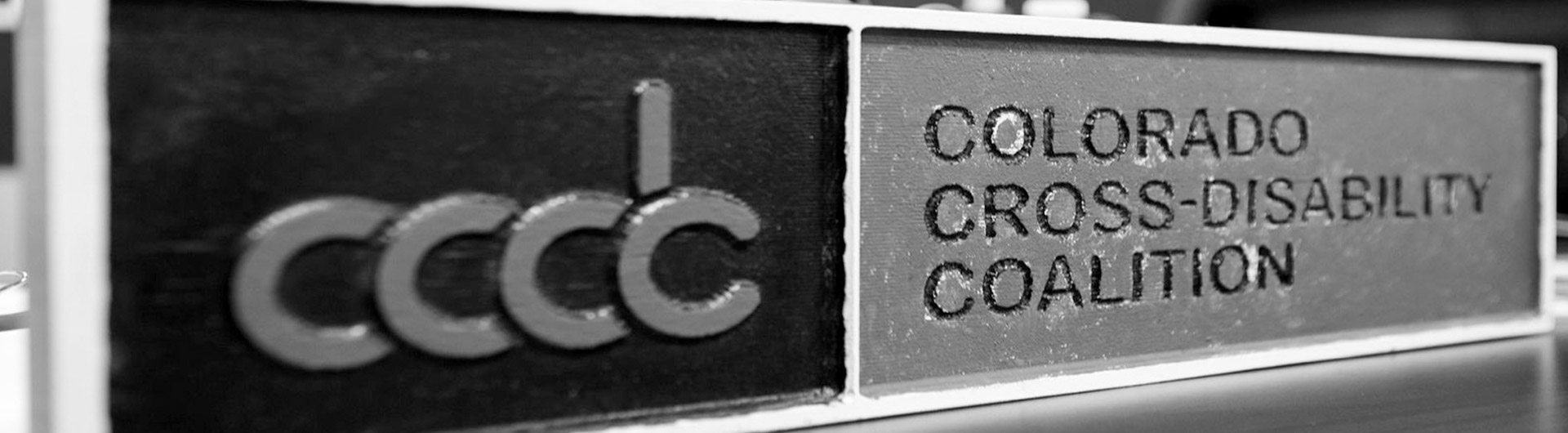Sign on a desk that reads CCDC Colorado Cross Disability Coalition